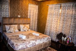 a bedroom with a bed with two towels on it at Amberwoodinn in Munglor