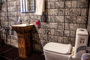 a bathroom with a toilet and a sink at Amberwoodinn in Munglor +15 photos