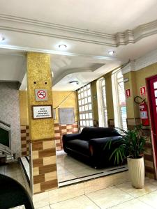 a room with a large black couch in a building at Hotel Independência Executive in Goiânia