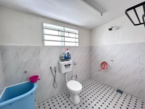 a bathroom with a toilet and a sink and a tub at Homestay Teera in Chemor