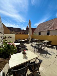 a patio with tables and chairs and an umbrella at Hotel Faaborg in Faaborg
