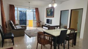 a living room with a dining room table and chairs at Merlin Home@Crown Imperial Court in Tanah Rata