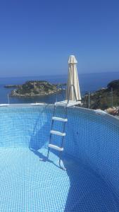 a ladder sitting on the edge of a swimming pool with a ladder at Casa di Mare Stegna in Archangelos