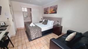 a hotel room with a bed and a couch at Golden Palms Motor Inn in Bundaberg