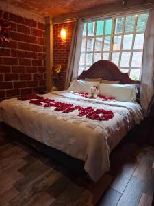 ein Schlafzimmer mit einem Bett, das mit roten Rosen bedeckt ist in der Unterkunft Chalet MQSTO in La Cañada