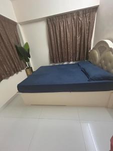 a bedroom with a bed with blue sheets and a window at 2 bhk flat available in tst in Hong Kong