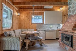 a living room with a couch and a table and a kitchen at Domki Letniskowe Kobyłocha in Kobyłocha +13 photos