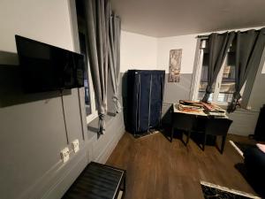 a living room with a flat screen tv and a table at Gengoult 2 in Toul