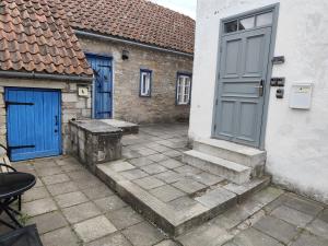 a building with a blue door and stairs in a courtyard at Kauba 6-5 Apartment in Kuressaare