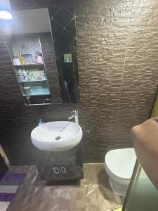a bathroom with a white sink and a toilet at 2 bhk flat available in tst in Hong Kong