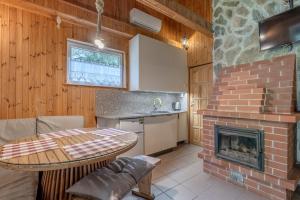 a kitchen and living room with a brick fireplace at Domki Letniskowe Kobyłocha in Kobyłocha