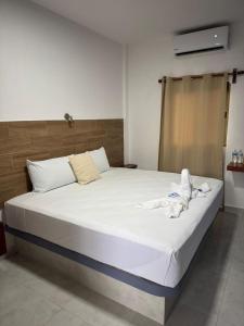 a bedroom with a large bed with white sheets at Posada El Pejelagarto in Bacalar