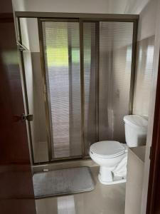 a bathroom with a toilet and a glass shower at Posada El Pejelagarto in Bacalar
