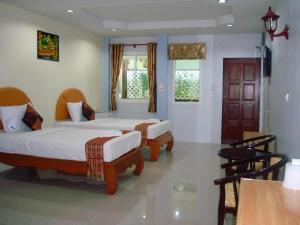 a bedroom with two beds and two windows at Nayai Resort in Chalong