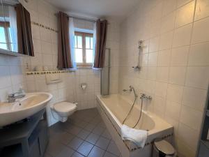 a bathroom with a tub and a toilet and a sink at Ferienwohnungen Am Kirchberg in Neualbenreuth +9 photos