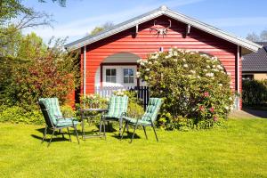 a table and chairs in front of a red house at Holzhaus im Schwedenstil in Scharnhorst