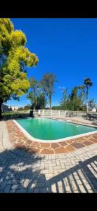 a large swimming pool with a tree in the background at Mthontsi Lodge in Kroomie