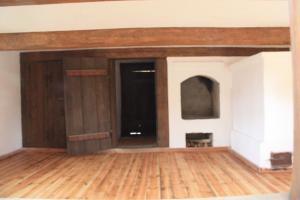 pusty salon z drewnianą podłogą i ścianą w obiekcie Agroturystyka Sominy Piotr w mieście Sominy