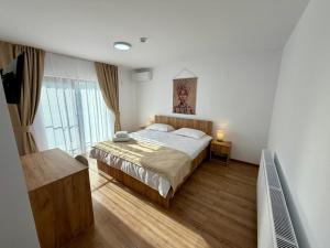 a bedroom with a bed and a large window at Hotel Victoria in Măldăreşti