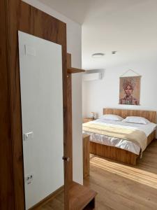 a bedroom with a bed and a wooden door at Hotel Victoria in Măldăreşti