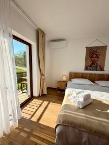 a bedroom with a bed and a large window at Hotel Victoria in Măldăreşti +35 photos