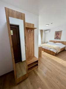 a bedroom with a bed and a wooden door at Hotel Victoria in Măldăreşti