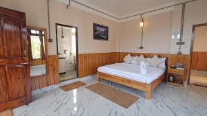 a bedroom with a white bed and a bathroom at Red Cherry Homestay, Nokdara in Lava +12 photos
