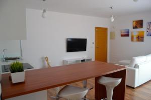 - un salon avec une table en bois et une télévision dans l'établissement Cotillo Beach & Sport, à El Cotillo