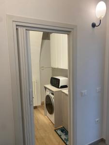a kitchen with a washing machine and a microwave at Casa La Turchese in Gualdo Tadino