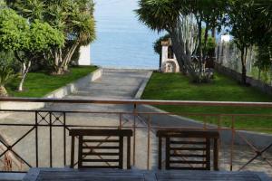 two chairs sitting on a balcony looking at the ocean at Villa Bella Loukisia Seafront 5BR Villa for 10 Near Athens in Loukísia