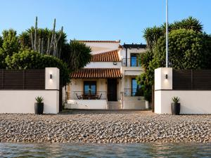 a house on the shore of a body of water at Villa Bella Loukisia Seafront 5BR Villa for 10 Near Athens in Loukísia