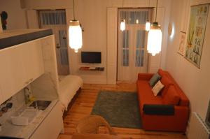 a living room with an orange couch and a television at Oporto Old In New in Porto