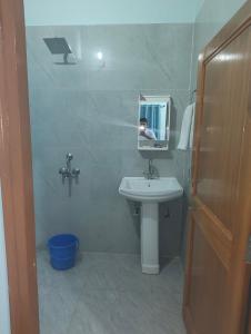 a small bathroom with a sink and a mirror at Rawat ji Homestay in Rāmnagar +18 photos