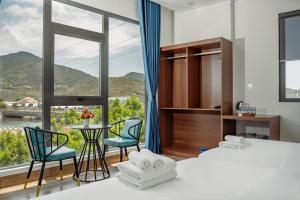 a hotel room with two beds and a table and chairs at Vinh Hy Horizon in Vĩnh Hy