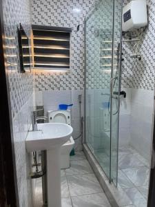 a bathroom with a toilet and a sink and a shower at Haven Residence in Rubuchi