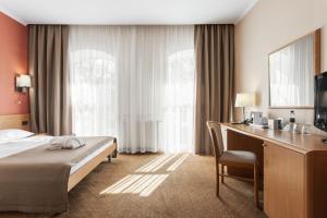 a hotel room with a bed and a desk at Alexandrovskiy Hotel in Odesa