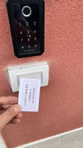 Eine Person, die eine Kreditkarte vor einer Wand hält in der Unterkunft Cilento Mare Jacuzzi in Agropoli