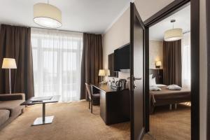 a hotel room with a bed and a desk at Alexandrovskiy Hotel in Odesa