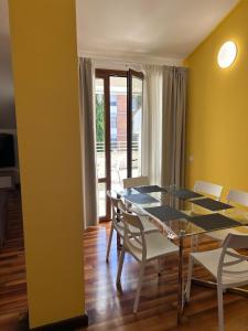 a dining room with a glass table and white chairs at Hotel Alex in Florence