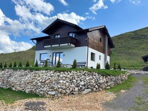 a house on a hill with a stone wall at Dealul Craiului in Şirnea