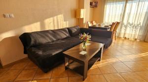 a living room with a black leather couch and a table at Apartment Segura 2BD in Rojales
