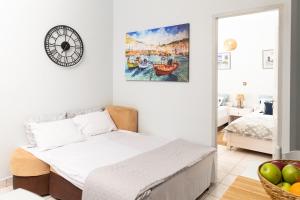 a bedroom with a bed and a clock on the wall at Touzla Blue Heaven in Orfánion
