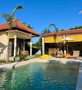 a house with a swimming pool in front of a house at Di rumah Vima homestay in Pemuteran