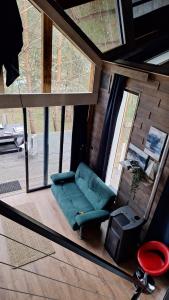 a living room with a green couch and a window at Domki Wieck in Czarna Woda