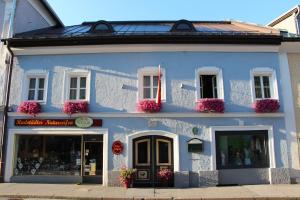 un edificio azul con flores delante en Stadtappartements Oppeneiger, en Radstadt