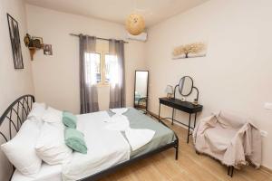 a bedroom with a bed with a mirror and a table at K&J House in Didyma