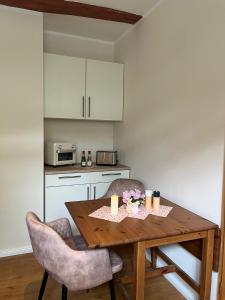 a kitchen with a wooden table and two chairs at Appartment Casa Verde in Lübberstedt