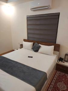 a bedroom with a large white bed with a large headboard at Hotel O Naveen Residancy in Manesar