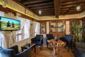 a living room with a tv and a table and chairs at Beliz Hanım Konakları in Gaziantep