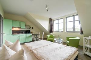 a room with a bed and a kitchen with green cabinets at An der Metow-Ferienpark Hotel in Plau am See